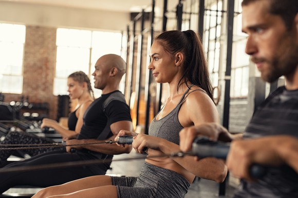 Men and women working out on a rowing machine
