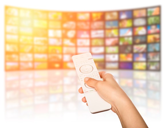 A person pointing a remote at a curved screen.