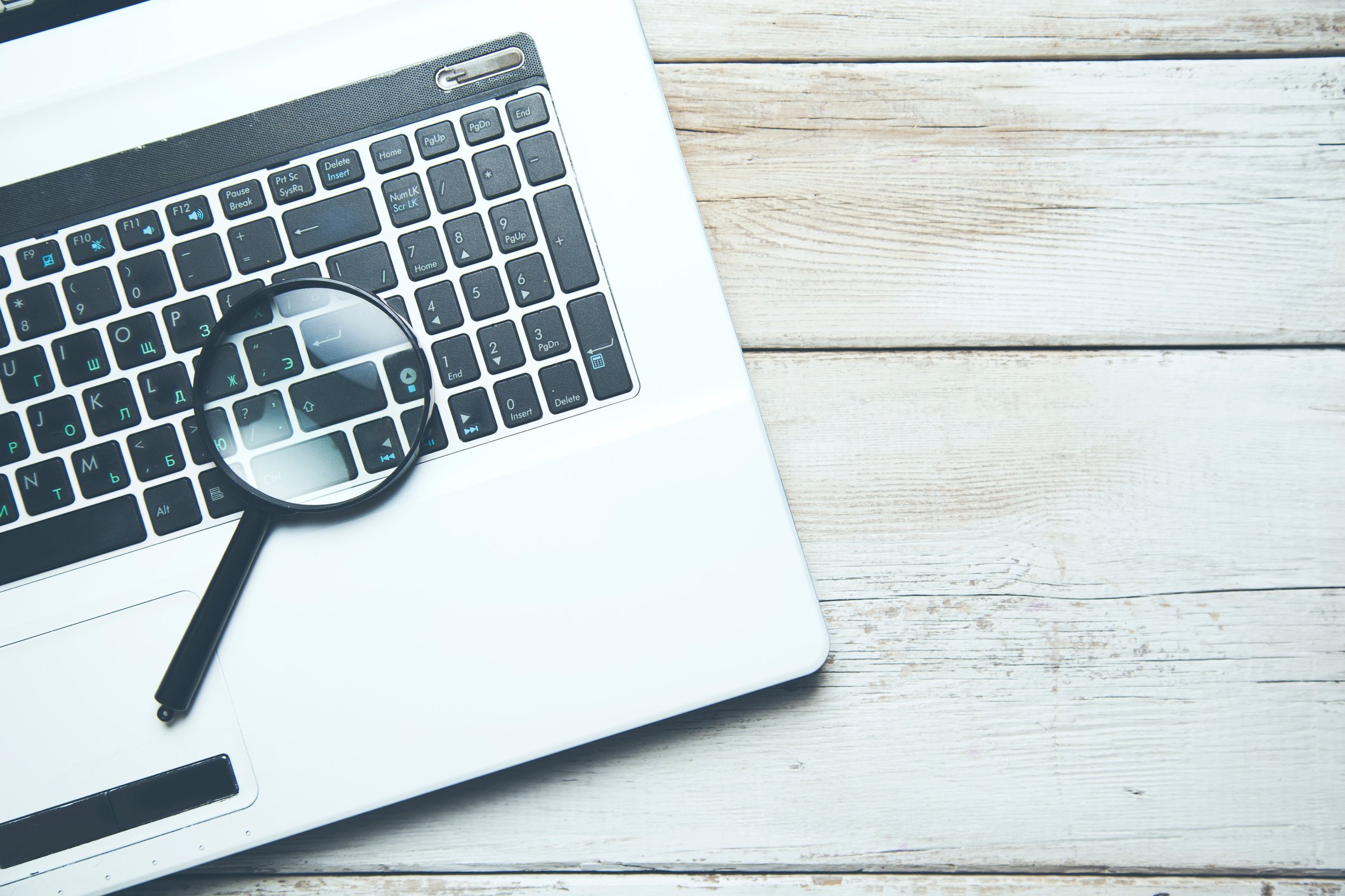 A magnifying glass and a laptop.