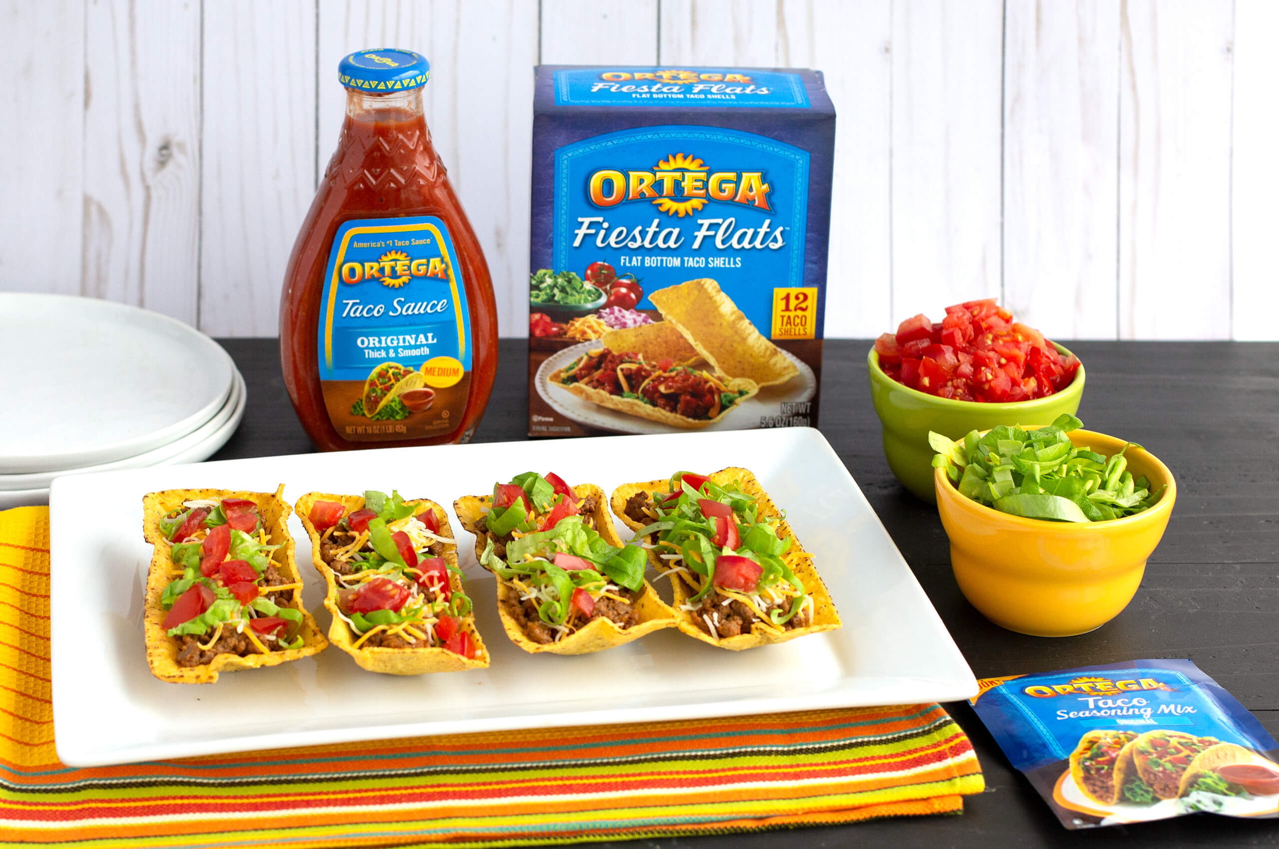 A plate of tacos surrounded by Ortega products.