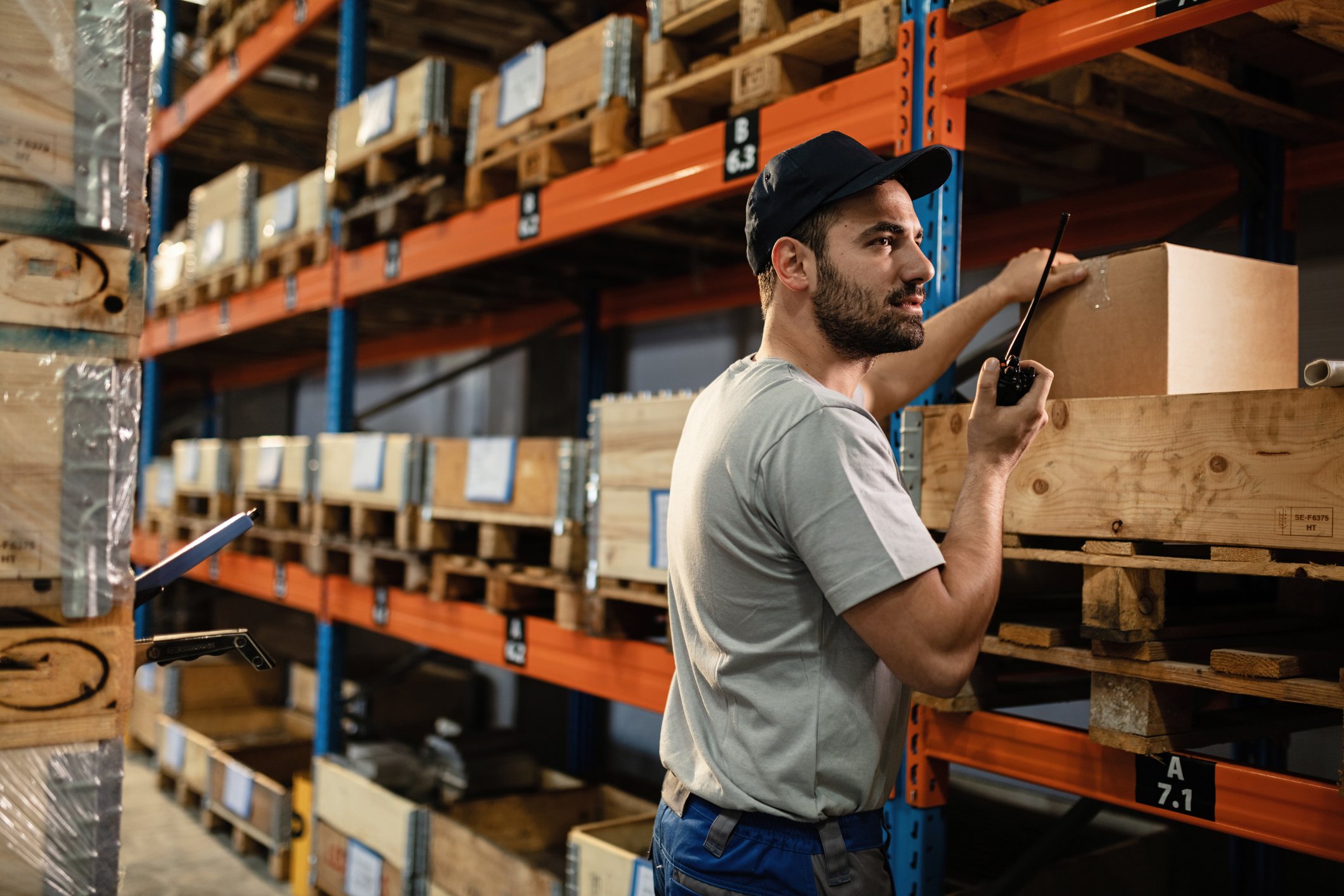 A warehouse worker pulls an item from a shelf.