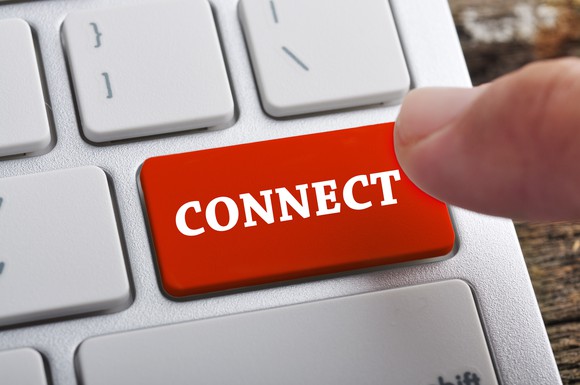 A finger hovers over a laptop keyboard where the "enter" key has been replaced by a red button labeled "connect"