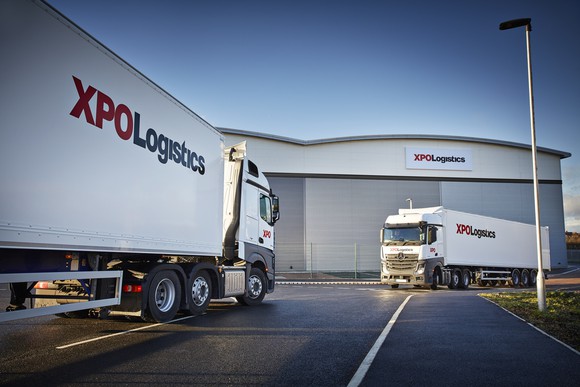 Two XPO semi-trucks at a distribution center.
