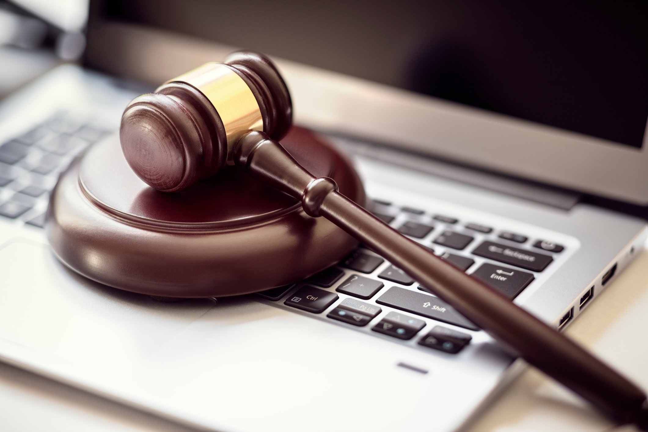 A gavel on top of a laptop.