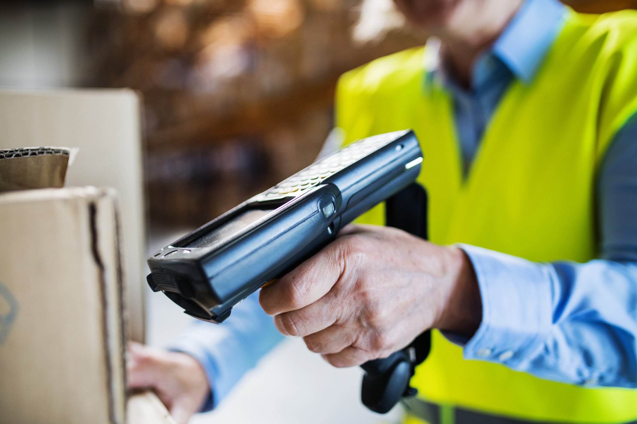 A handheld scanner being used in a warehouse.