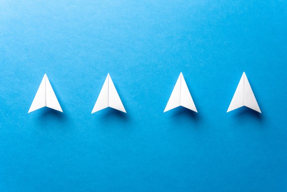 Four paper-plane arrows pointing up