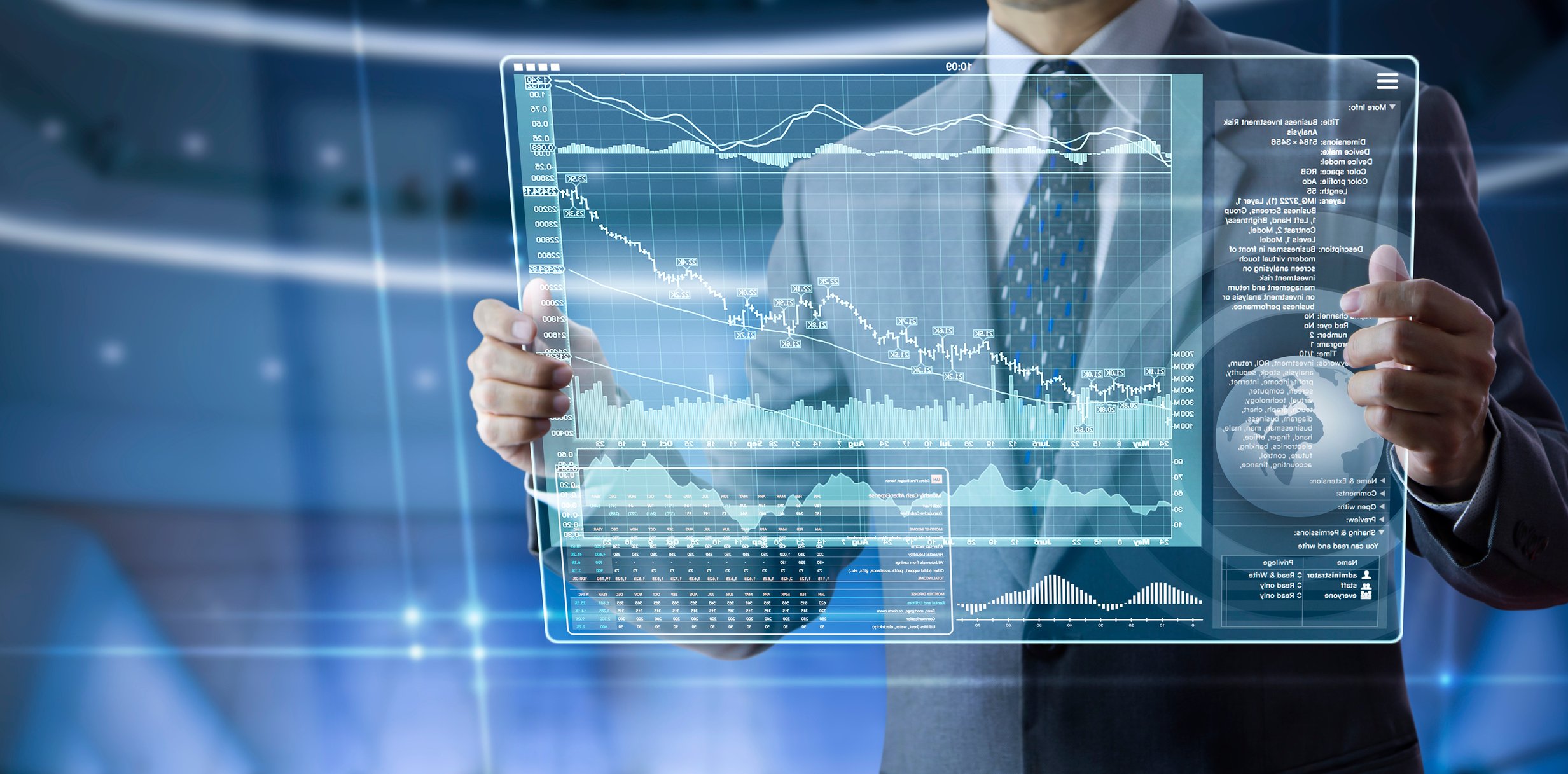 Man in suit seen from neck-down holds up a virtual screen in front of him with a financial graph on it and a picture of a globe. 