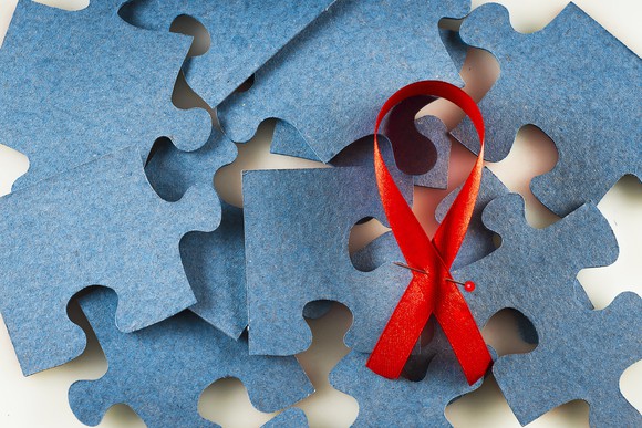 Red ribbon on top of blue jigsaw puzzle pieces