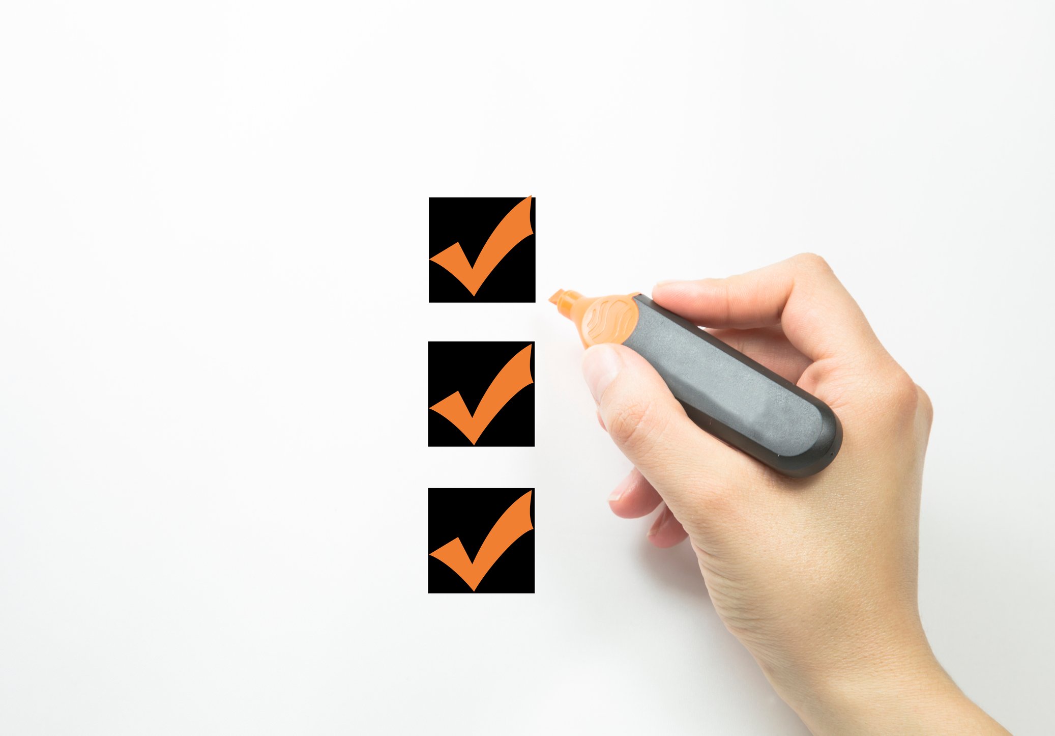 Hand holding a marker with three boxes checked