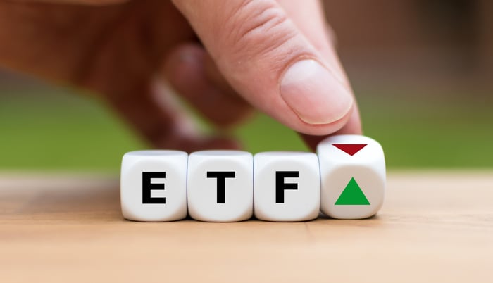 Blocks with the letters E T and F with a hand turning over a fourth block revealing a green up arrow.