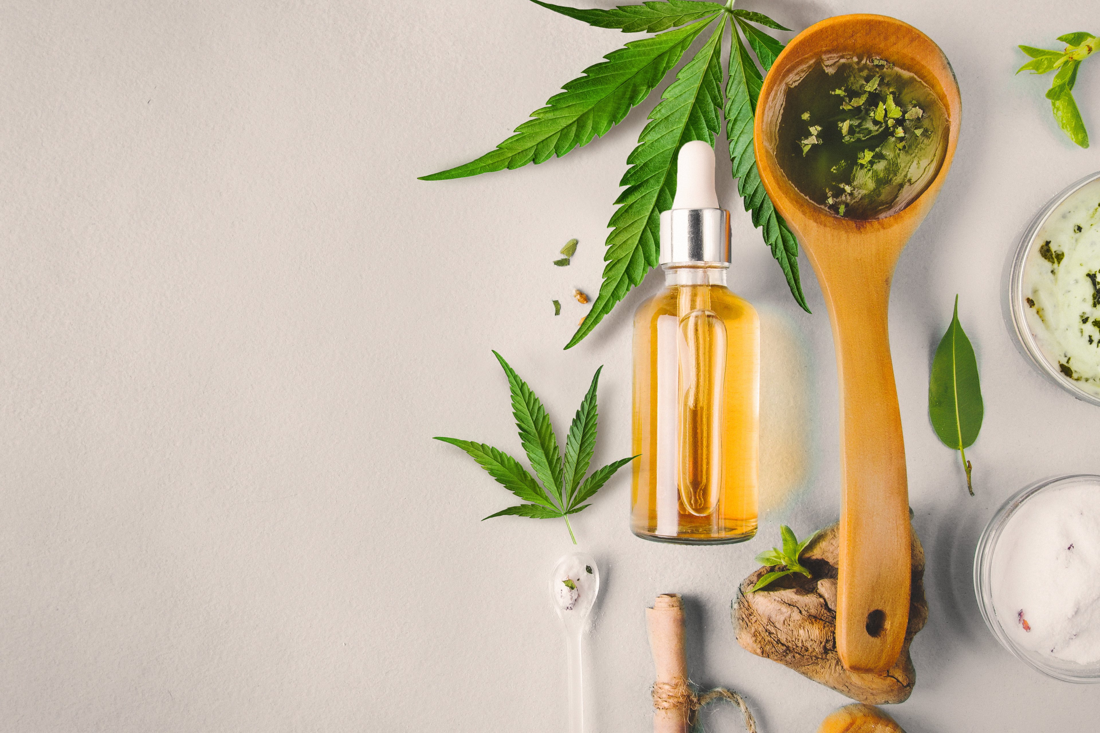 Cannabidiol oil bottle and cannabis leaves