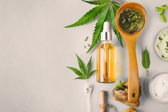 Cannabidiol oil bottle and cannabis leaves