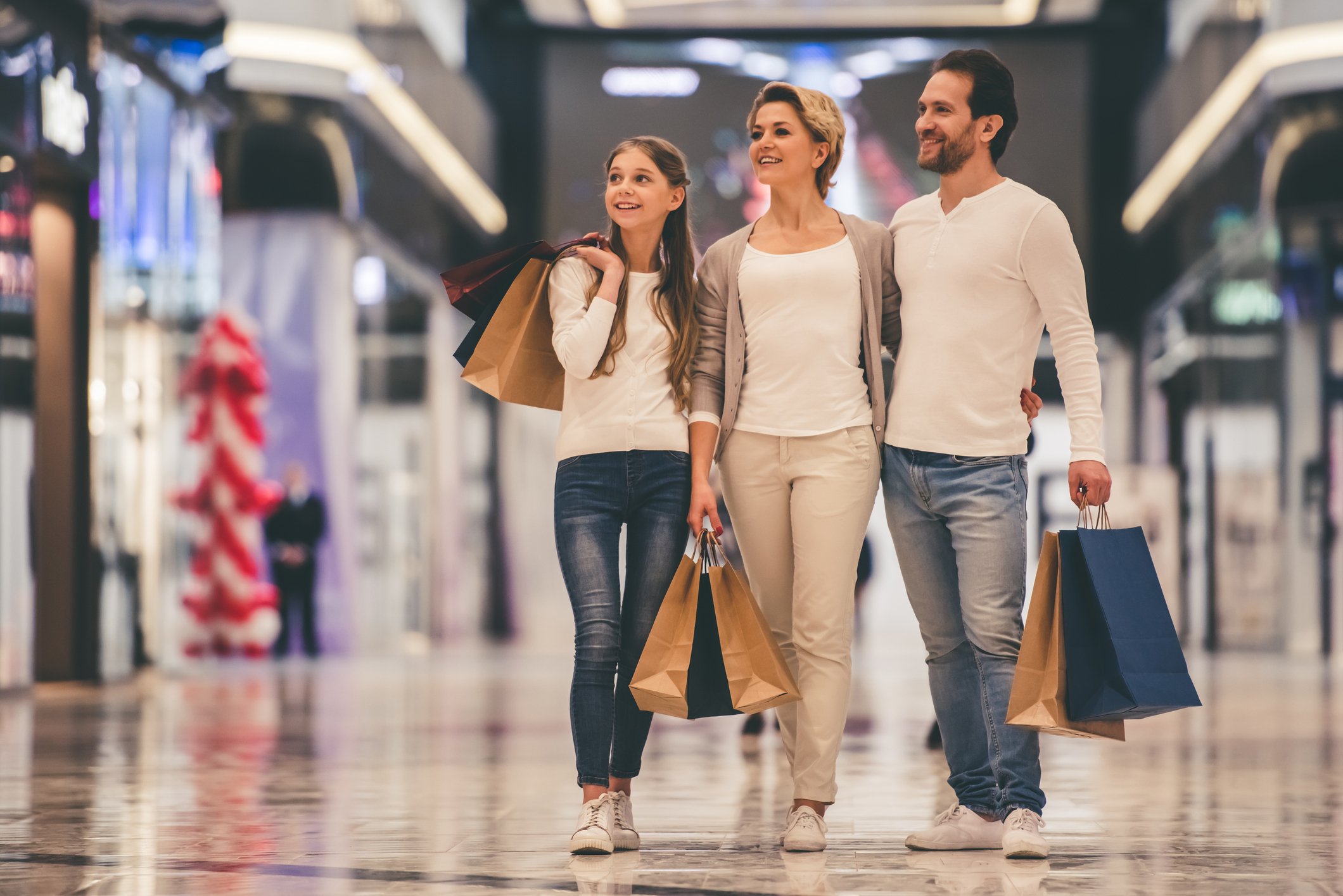 Man, woman, and child shopping at a mail. 