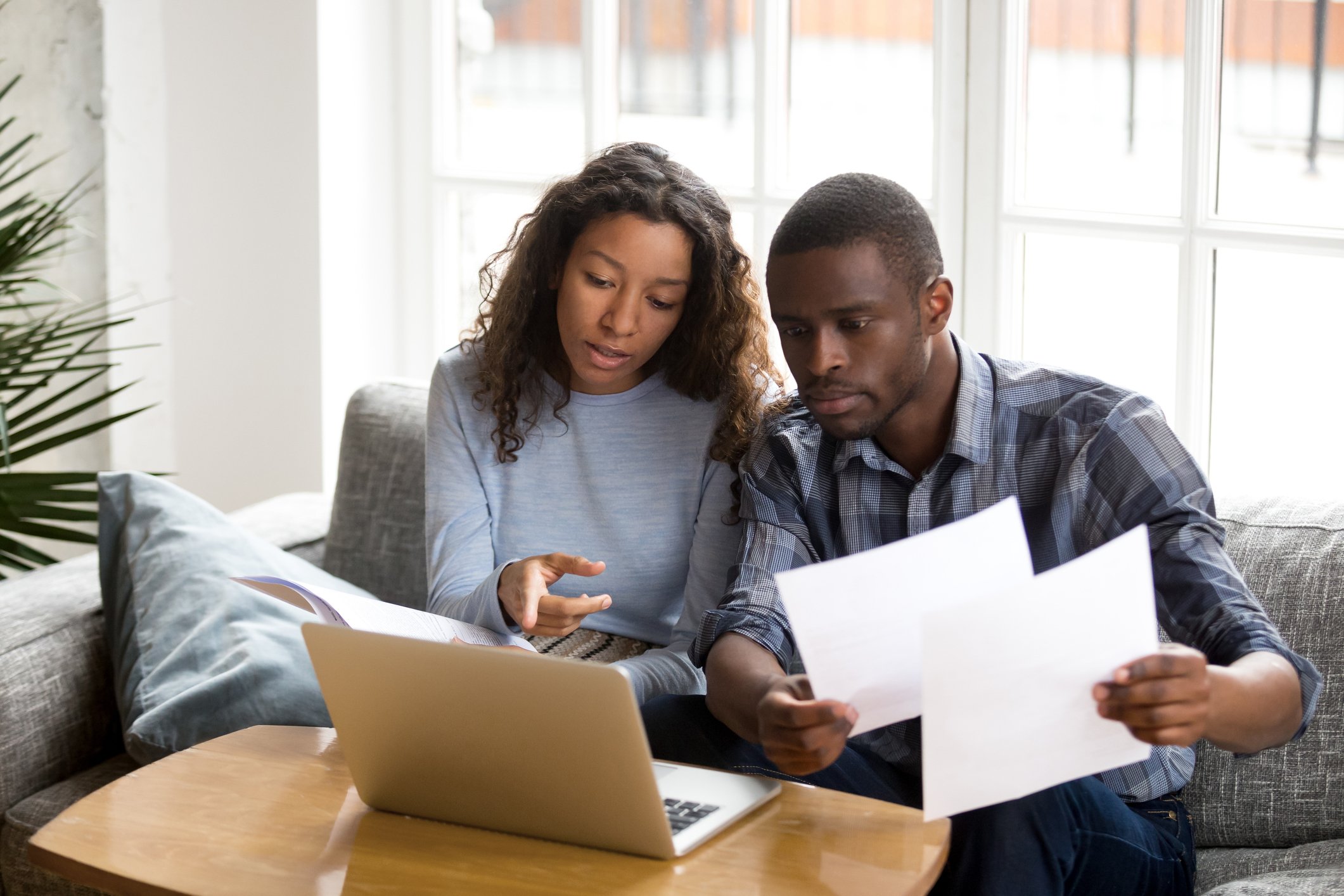 Couple with documents using laptop  