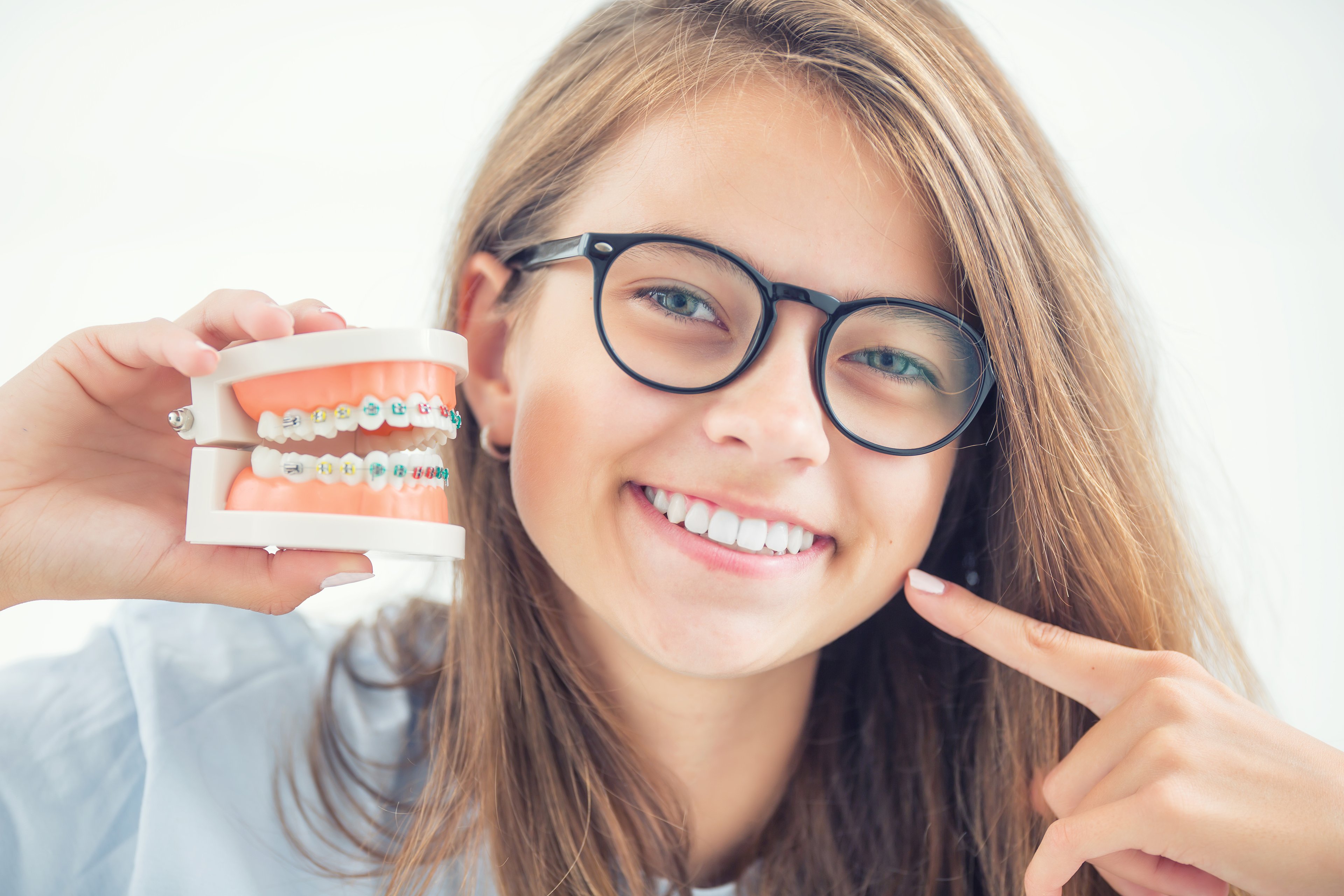 Model of a dental braces in the hand of a young girl.