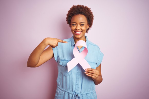 African American woman holding breast cancer ribbon.