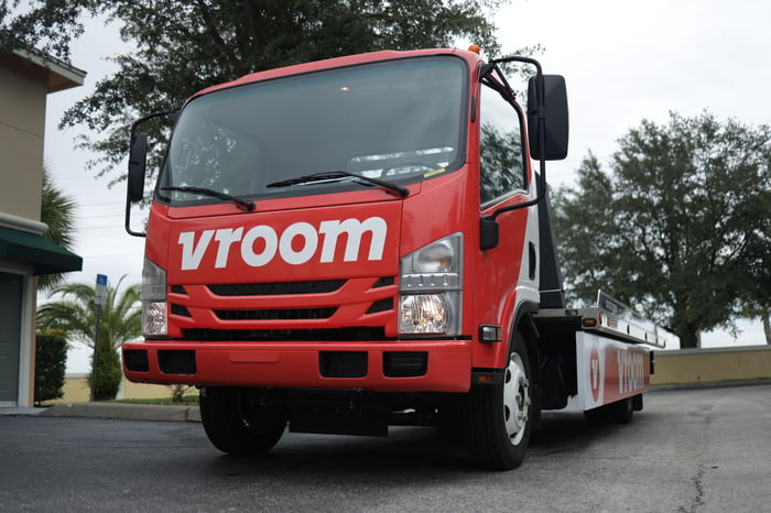 A Vroom transportation truck with an empty flatbed