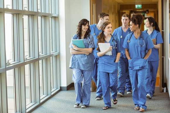 A group of medical students walking down a hallway.