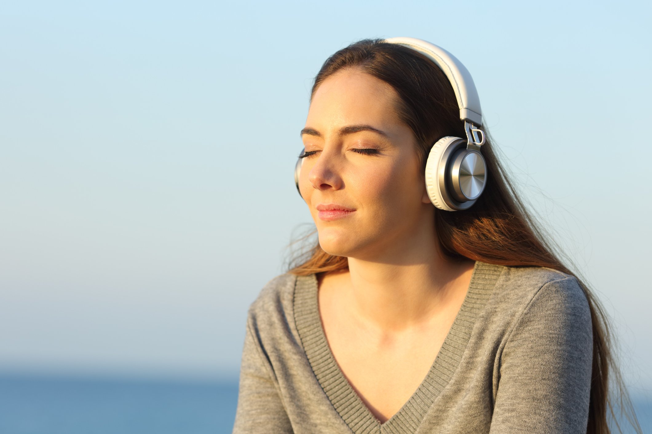 A woman listens to music on headphones.