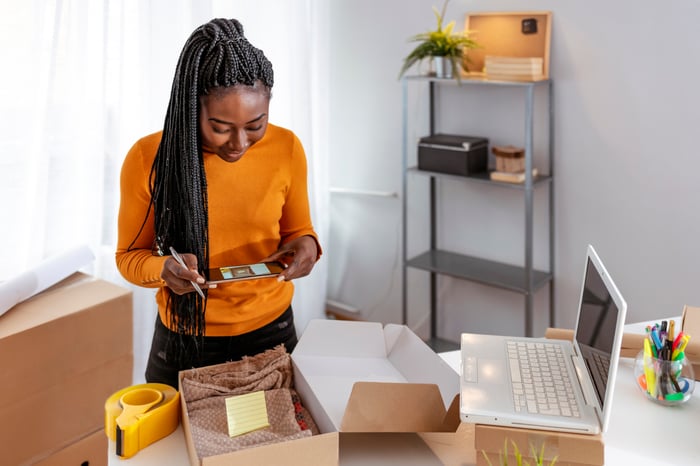 A female small business owner packaging an order to be shipped. 