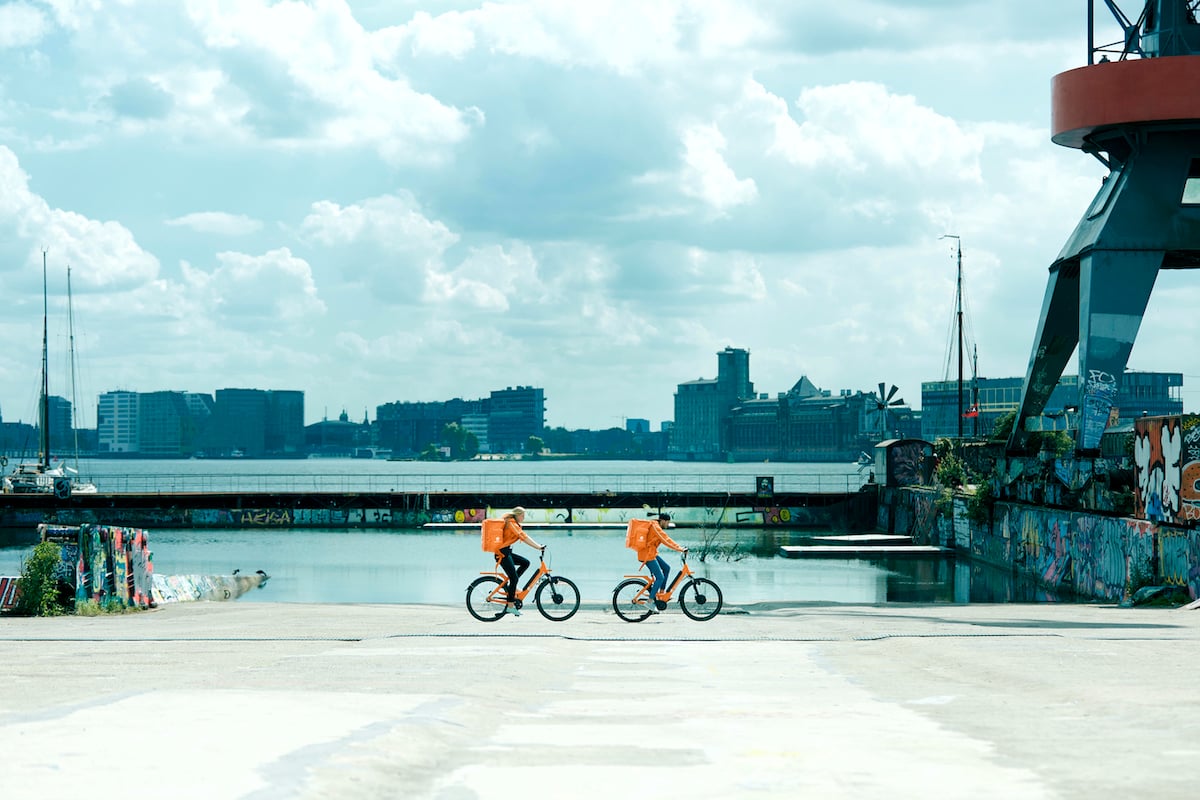 Just Eat Takeaway.com delivery personnel ride bikes while delivering food.