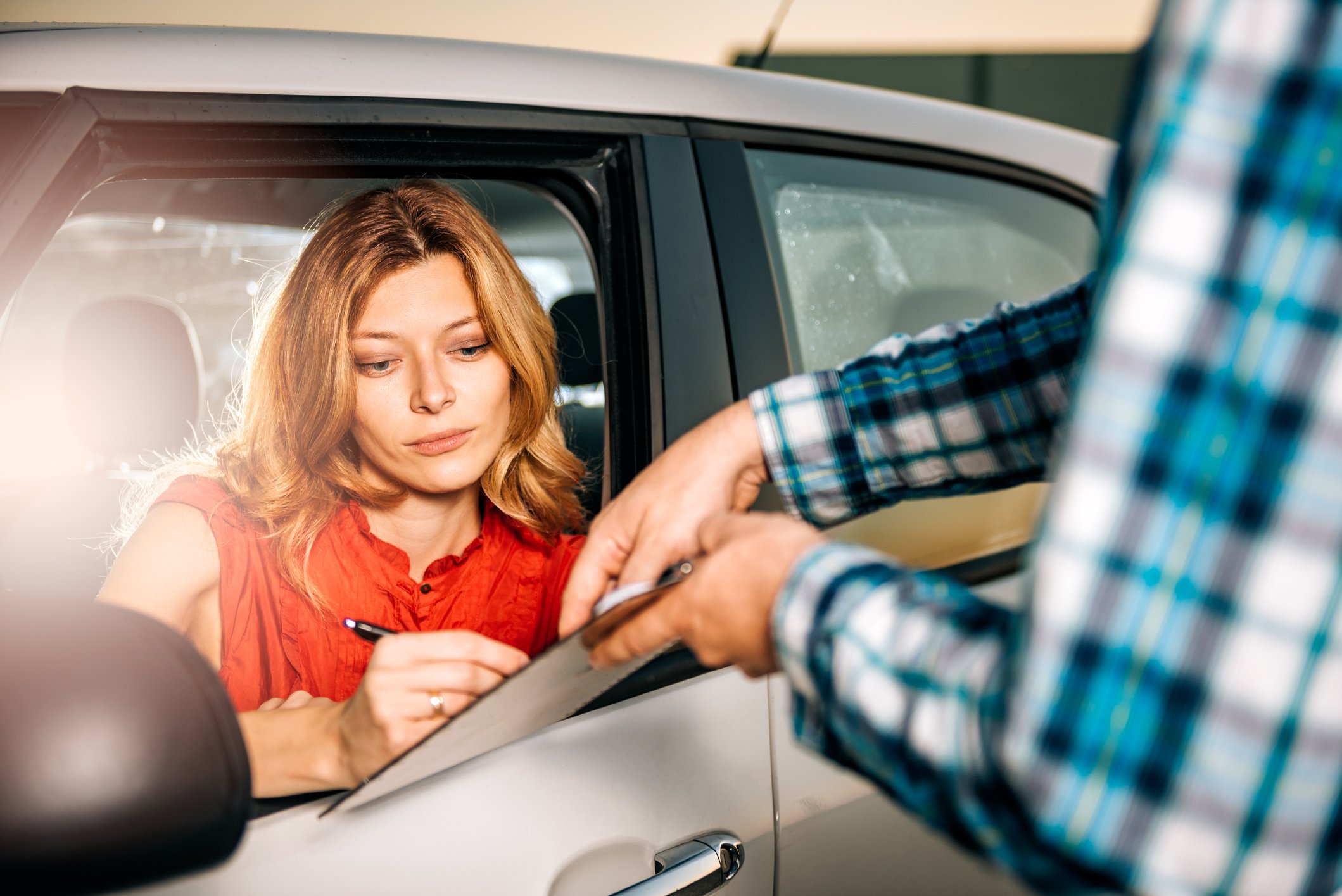 woman signing for vehicle rental