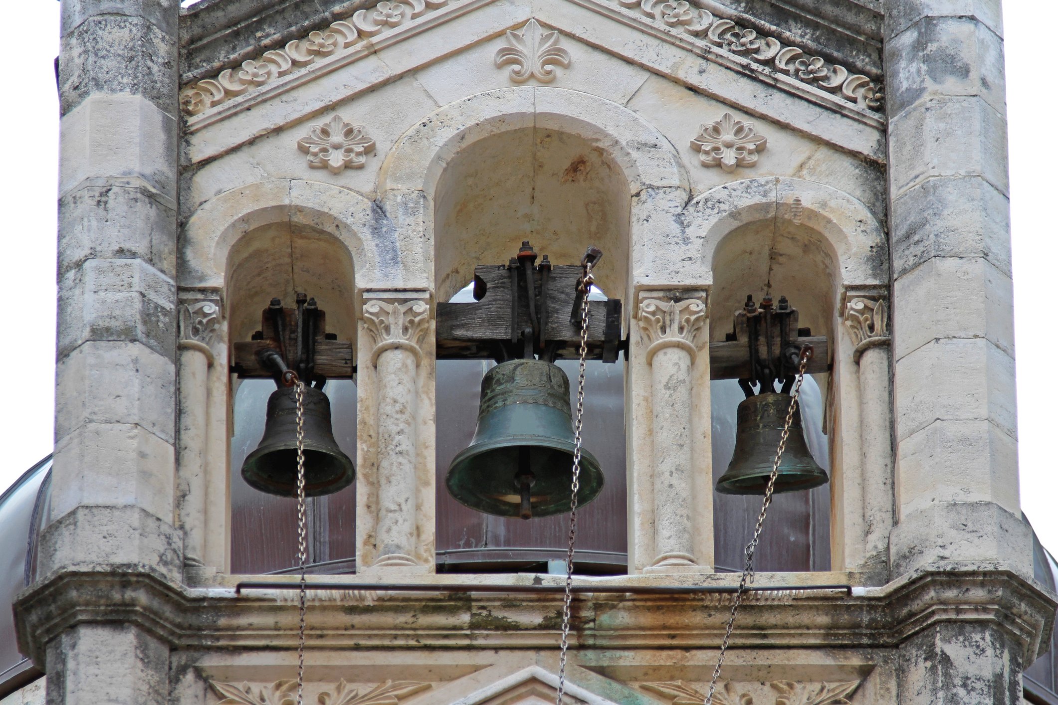 Three large church bells ringing in a tower
