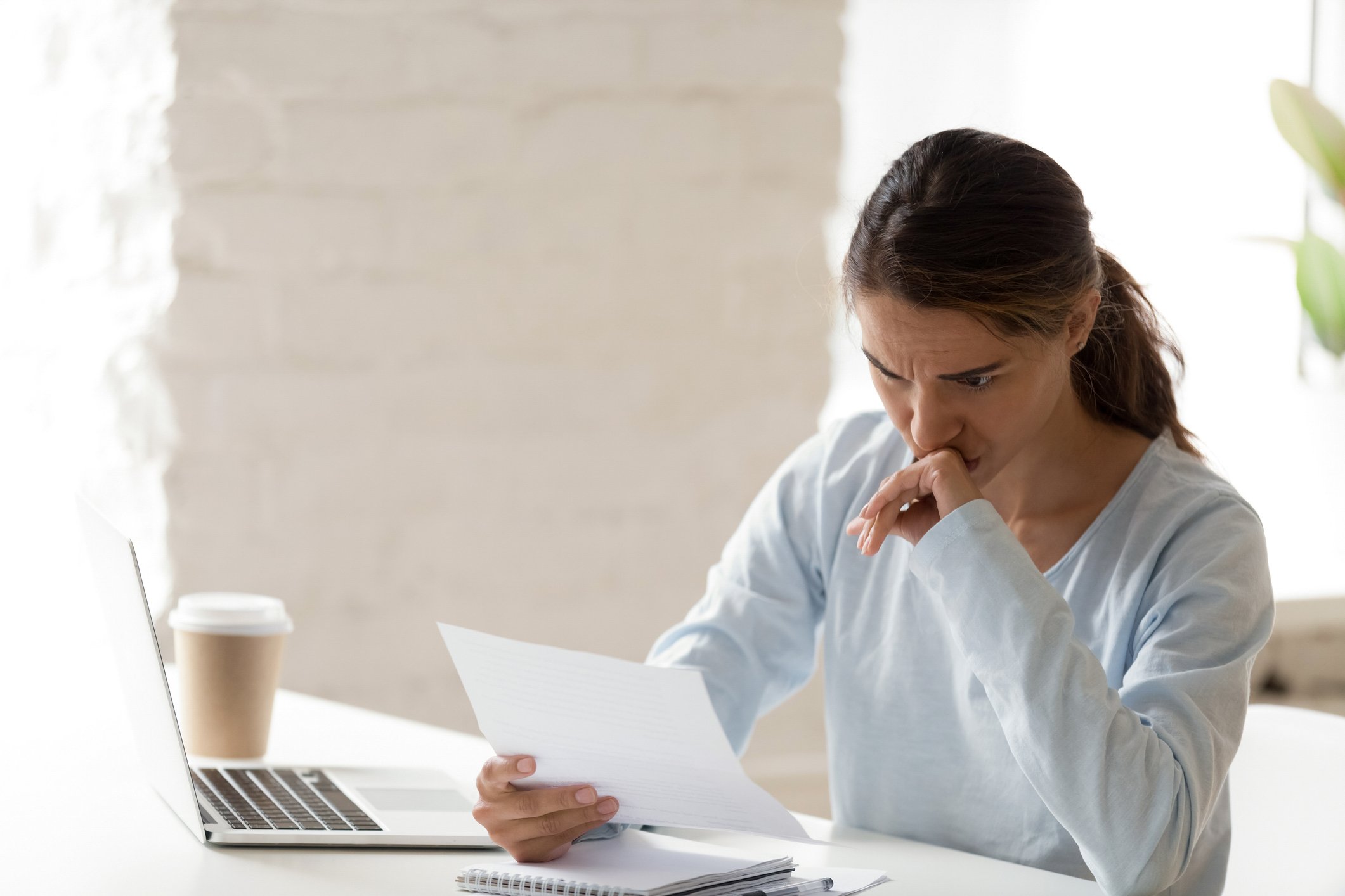 Woman frowning while reviewing paperwork.