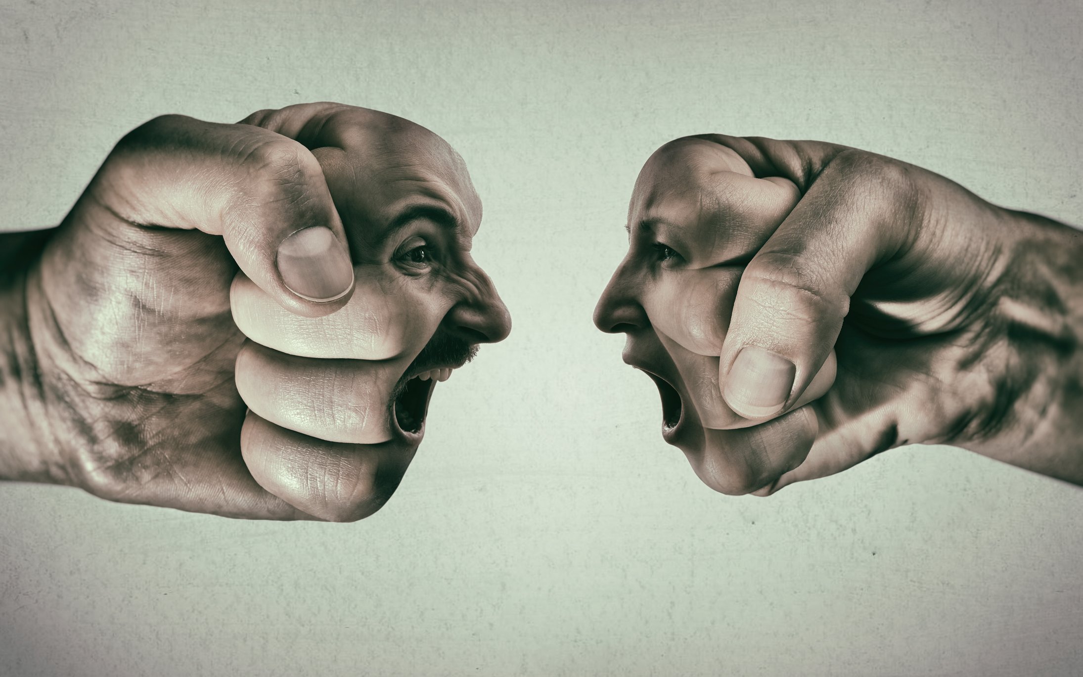A shouting duel between two faces superimposed on fists.