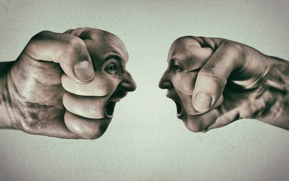 A shouting duel between two faces superimposed on fists.