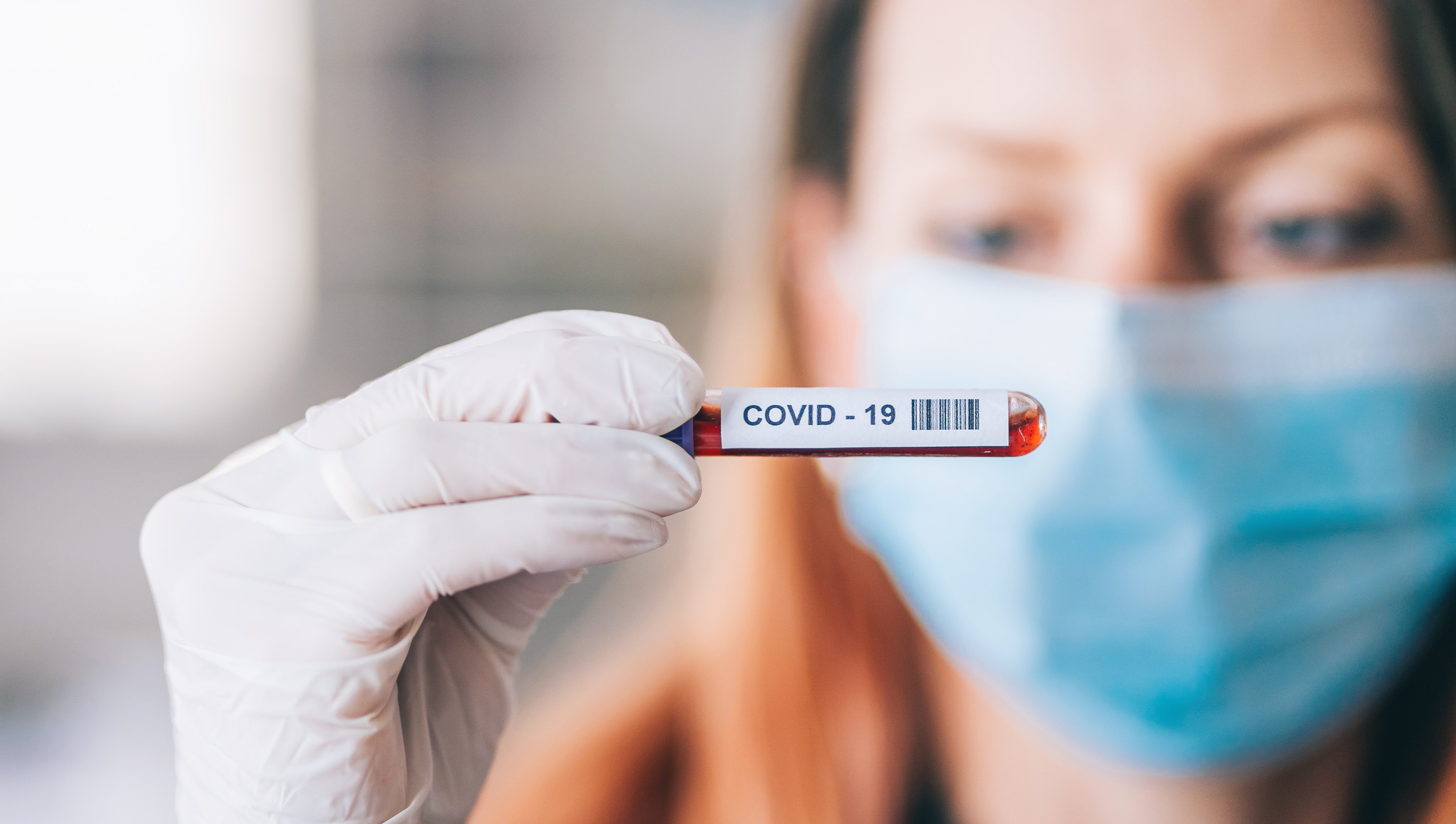 A doctor looks at a COVID-19 vial