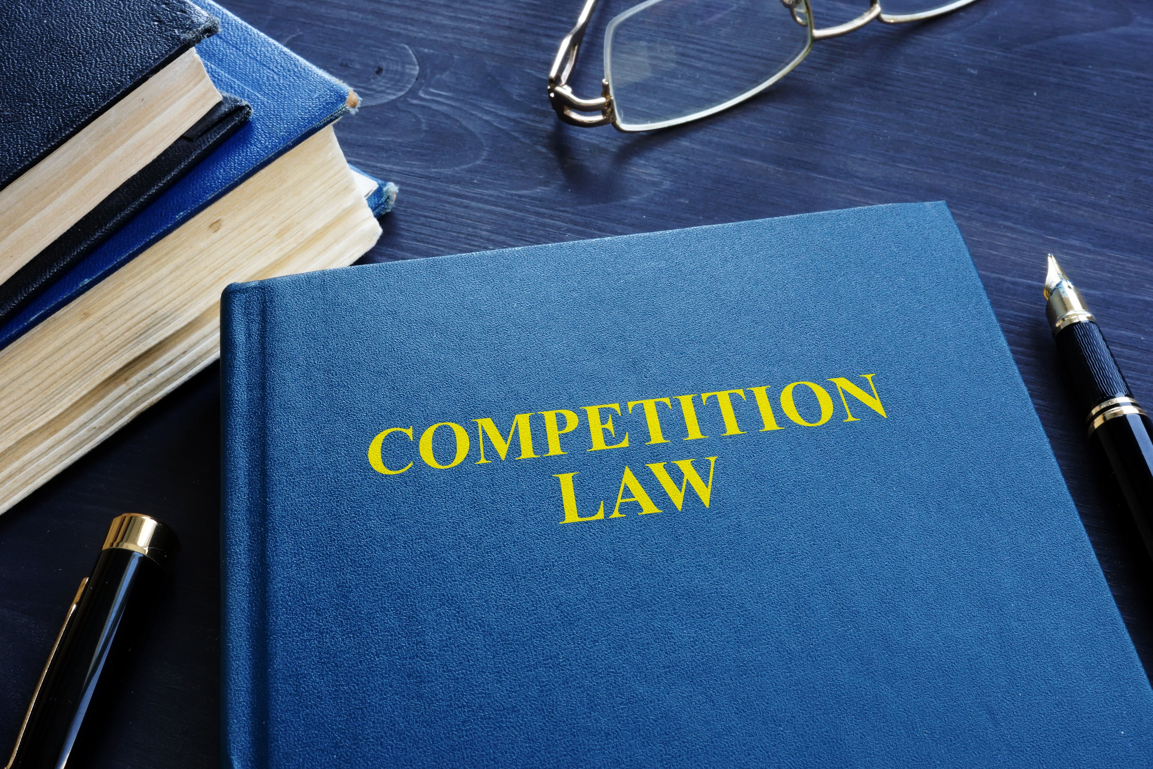 A blue competition law textbook sitting on a desk.