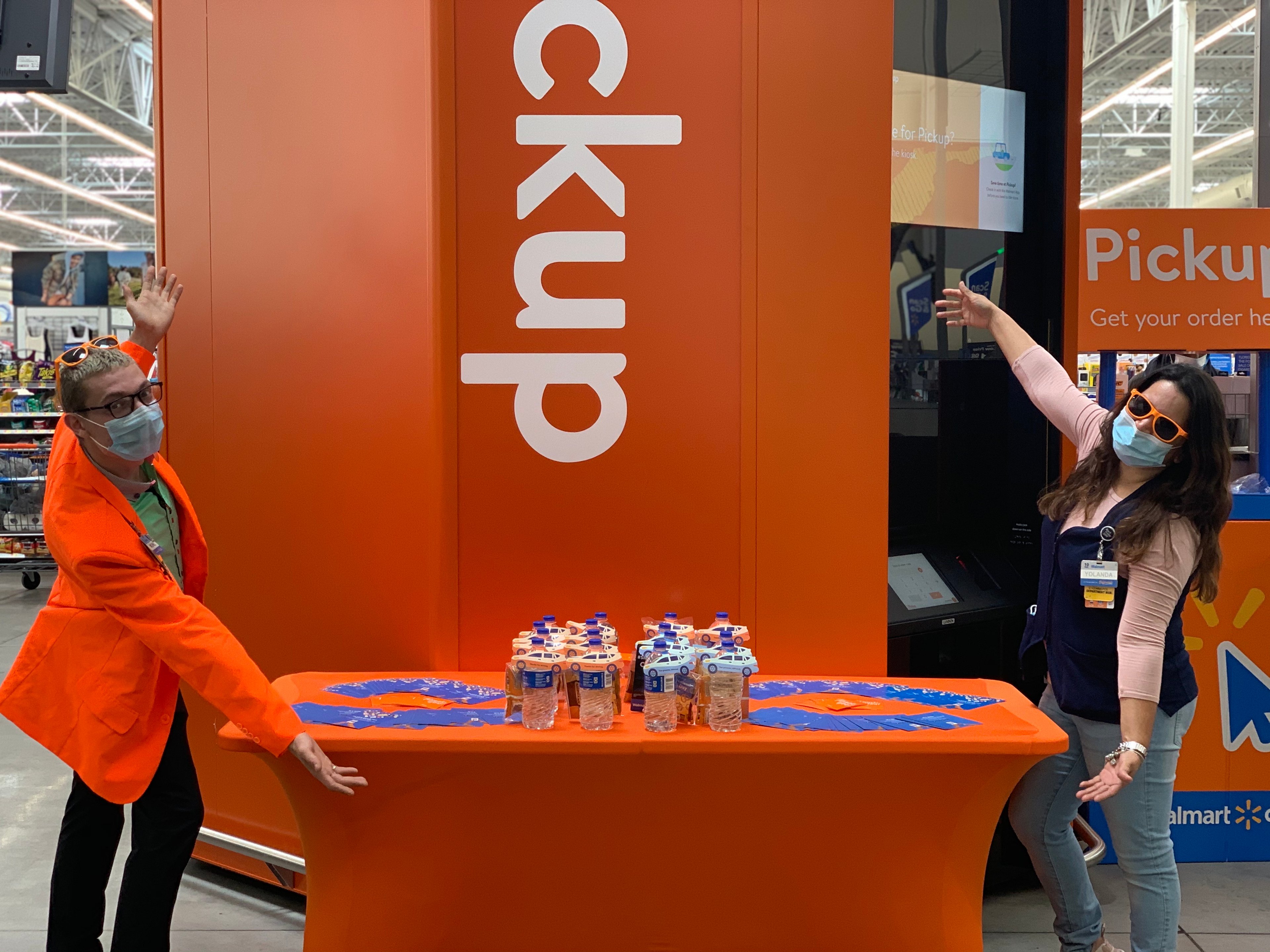 Two Walmart employees presenting a pick-up tower