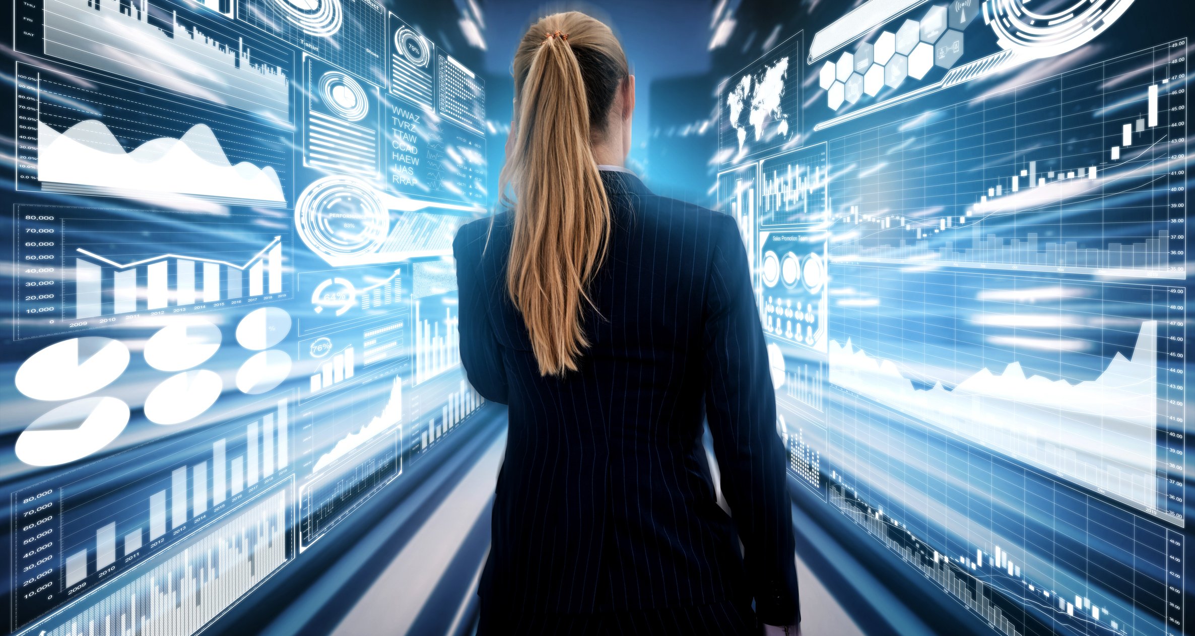 Viewed from back a woman walks down a hallway with animations of graphs and charts whizzing by on both walls. 