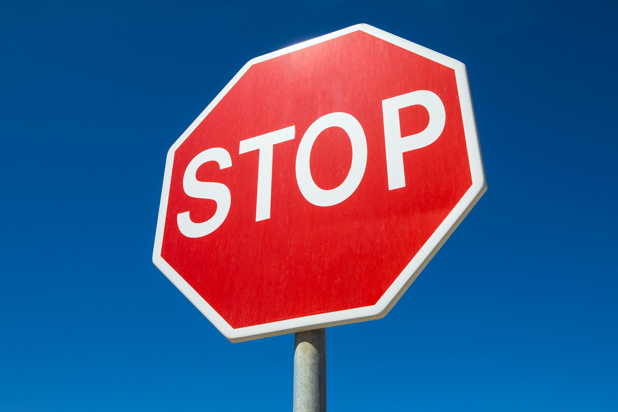 Regular, eight-sided stop sign with white letters on red background
