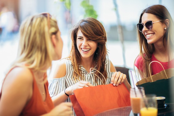 Three women laughing and shopping.