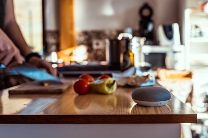 A smart speaker sitting on a kitchen counter. 