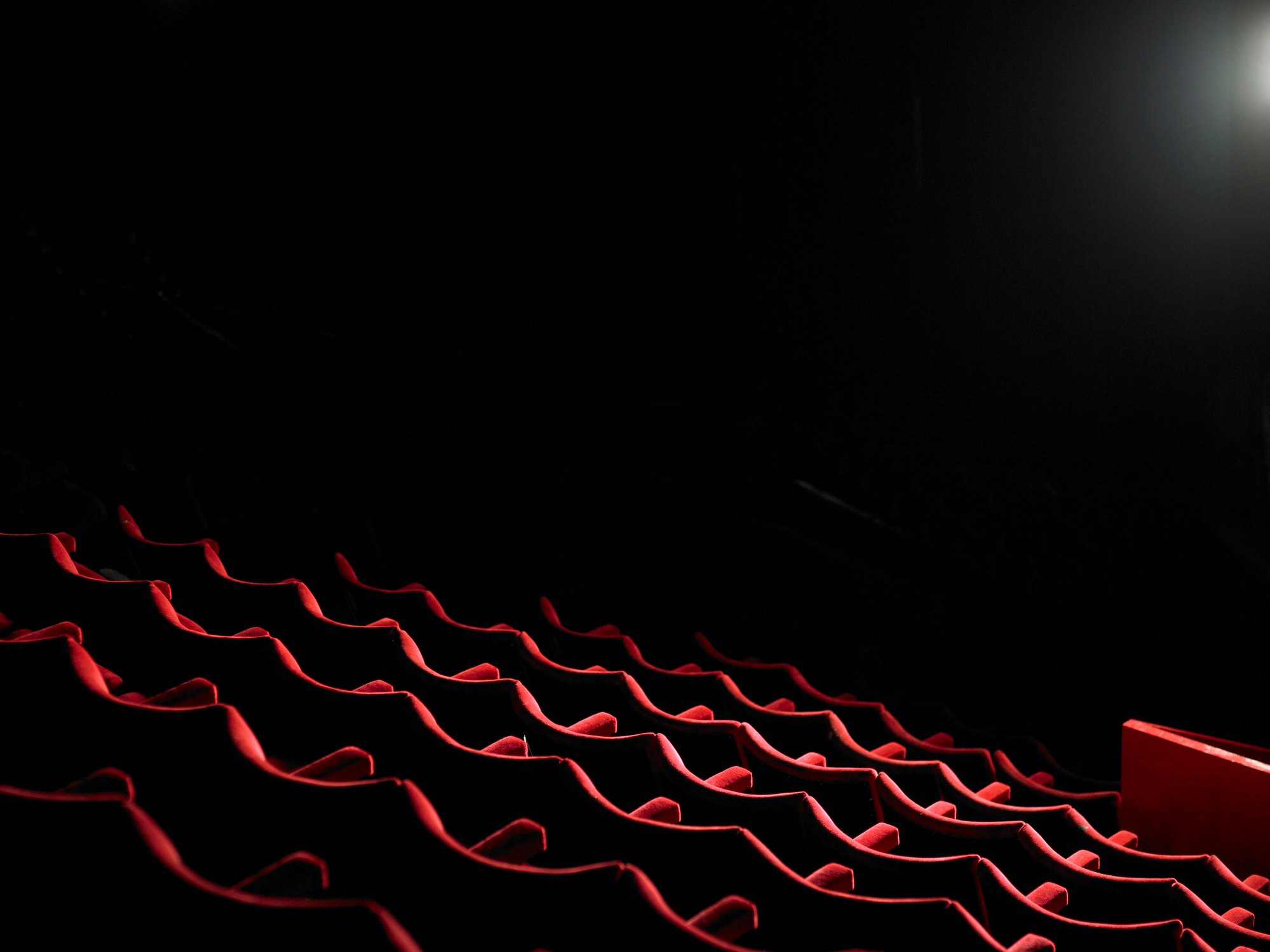 Photo of the empty seats in a dark movie theater.