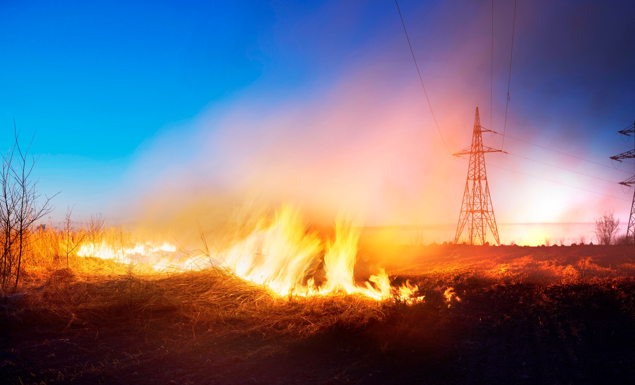 wildfire burning under transmission lines