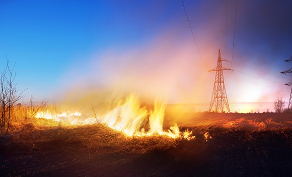 wildfire burning under transmission lines