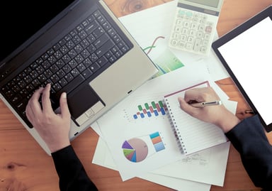 person crunching numbers by their laptop