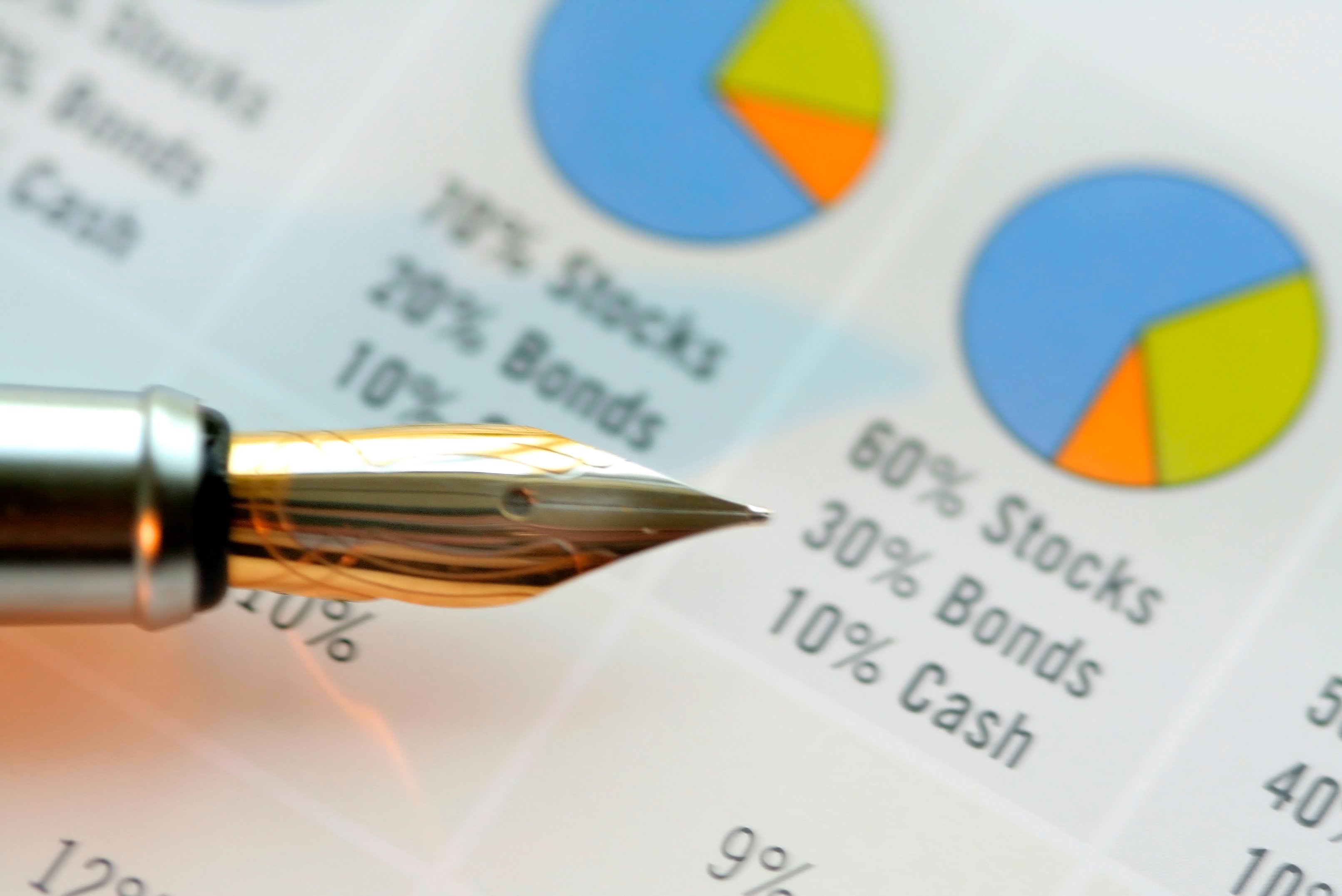 Pen pointing toward pie chart showing allocation of stocks, bonds, and cash