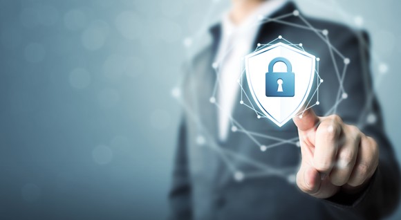 A man has his finger on a shield and padlock icon