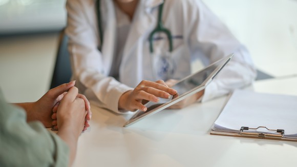 Doctor using a tablet to review information with a patient. 