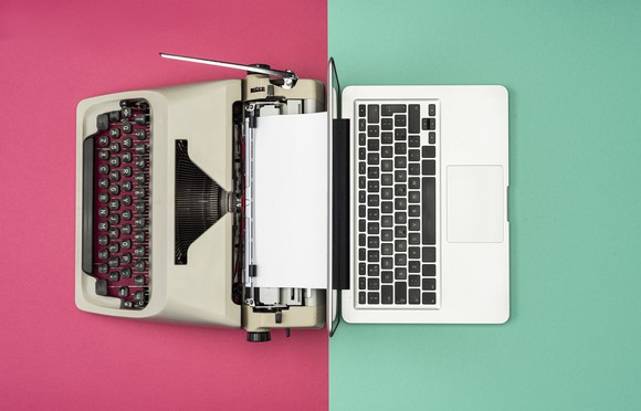 A Typewriter next to a laptop to signify the shift to the digital era. 