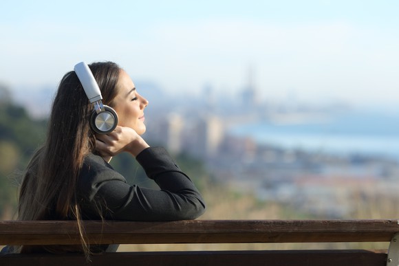 A young woman listens to music on headphones.