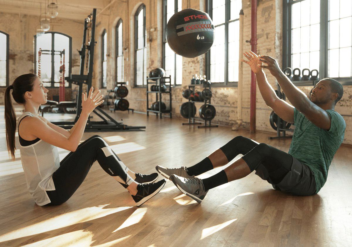 Man and woman throwing a workout ball