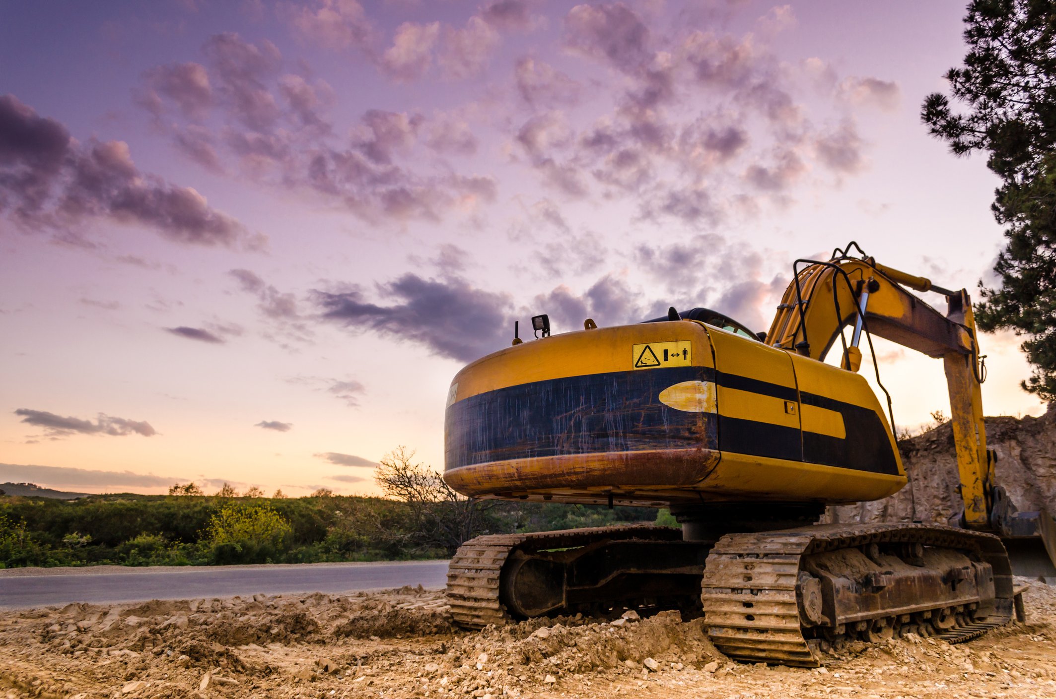 An excavator working beside a road