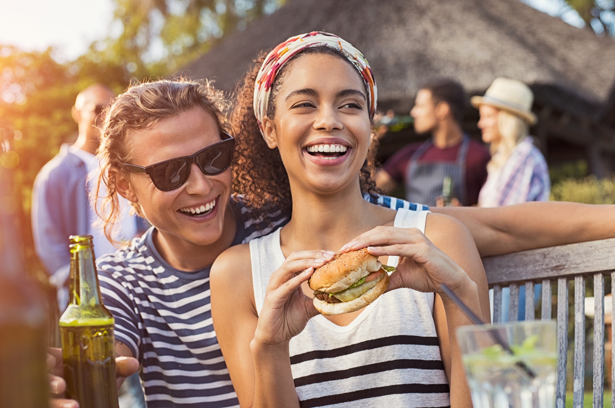 A couple enjoys a veggie burger at a summer barbecue.