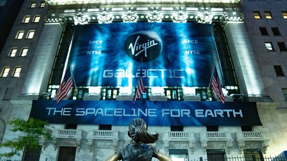 New York Stock Exchange with banner about Virgin Galactic hanging from columns and lit up.